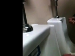 two slim dicks getting wanked at the urinals